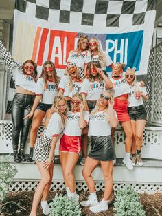 a group of women posing for a photo in front of a wall with the word hawaii on it