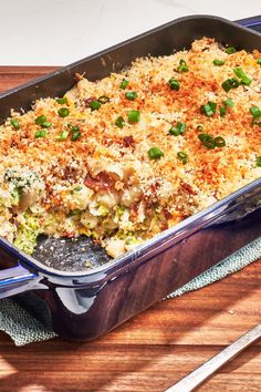 a casserole dish with broccoli and cheese in it on a wooden table