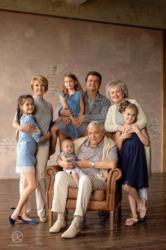 an older man sitting in a chair with his family