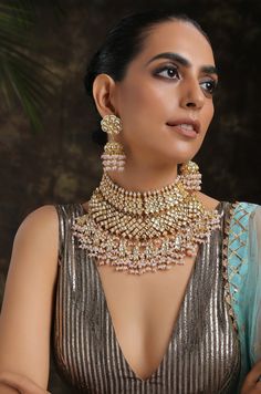 This opulent choker set is fit for a bride and even her close ones attending the wedding. This choker is a perfect amalgam of timeless style and drama that draws in attention. Necklace Closure - Adjustable Dori Earrings Closure - Push Back Style Tip - When it comes to getting a classic look, nothing can be better than kundan. This necklace set is fit for a woman who is fiercely independent yet rooted in traditional and cultural heritage, carving her own style with classic and timeless fashion ch Meenakari Choker For Bridal Reception, Meenakari Bridal Choker For Reception, Kundan Choker Jewelry Sets For Wedding, Heavy Choker Bridal Necklace For Reception, Heavy Bridal Choker Necklace For Reception, Heavy Bridal Choker For Reception, Kundan Choker Sets For Wedding, Bridal Choker Necklace With Tilla For Reception, Hand Set Jewelry Sets For Wedding