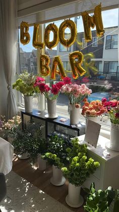 flowers and plants are on display in front of a window with the words bloom bar