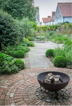 an outdoor fire pit in the middle of a garden