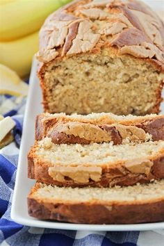 a loaf of banana bread sitting on top of a white plate next to some bananas