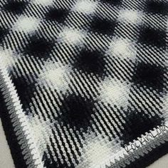 a black and white checkered blanket laying on top of a table