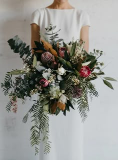 a woman holding a bouquet of flowers and greenery in front of her face, with the text send message below