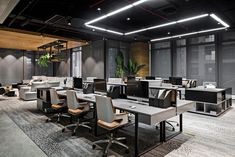 an empty office with chairs and desks in the middle of it, surrounded by large windows