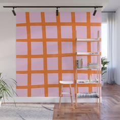 an orange and pink wall mural in a living room with shelves on either side of the wall