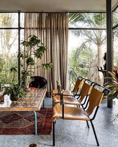 a living room filled with lots of furniture and plants