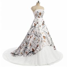 a dress on a mannequin with white and brown flowers in the skirt,