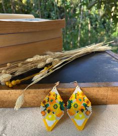 a pair of yellow beaded earrings sitting on top of a table