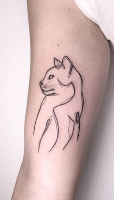 a cat tattoo on the left arm is shown in black and grey ink, it has a line drawing of a cat's head