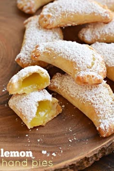 lemon hand pies on a wooden plate with powdered sugar