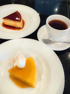 two white plates topped with different types of desserts next to cups and saucers