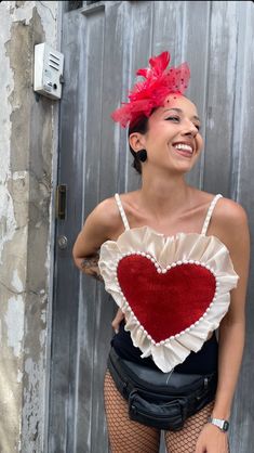 a woman in fishnet tights and a heart shaped top poses for the camera