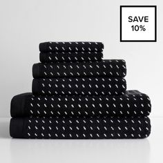 black towels stacked on top of each other in front of a white background with the sale sign