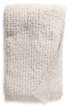 the textured blanket is white and has an uneven pattern on it's edges