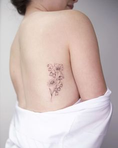 a woman with a flower tattoo on her shoulder