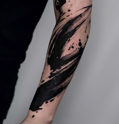 a man's arm with black ink splattered on it