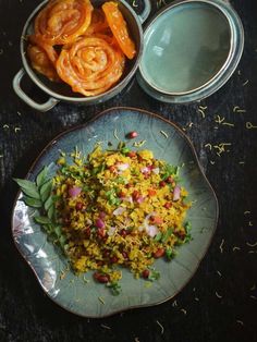 a plate with rice and vegetables on it next to two bowls filled with shrimp rings