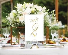 the table is set with white flowers and place cards