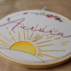 an embroidered sun with the word arizona on it is shown in front of a wooden hoop