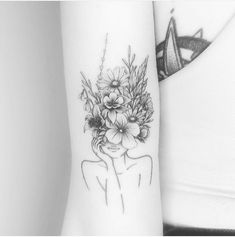 a black and white photo of a woman's arm with flowers on it