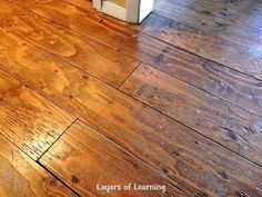 a wooden floor with a refrigerator in the background