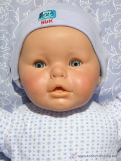 a baby doll with a blue hat on it's head is looking up at the camera