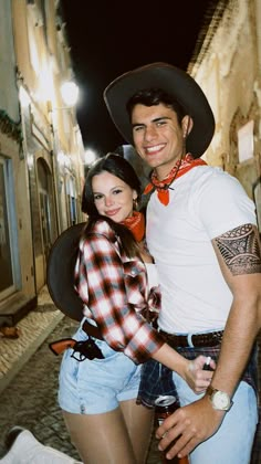 a man standing next to a woman wearing a cowboy hat