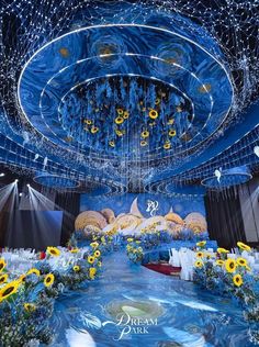 an elaborately decorated stage with sunflowers and other decorations in the center is lit up by blue lights