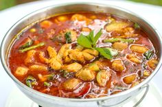 a pot filled with lots of food on top of a white tablecloth covered plate