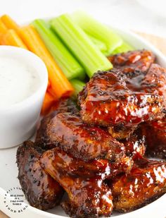 the plate is full of meat and vegetables with dipping sauce on top, along with celery