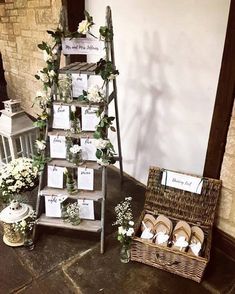 a small tree made out of wooden crates with cards on them and flowers in vases next to it