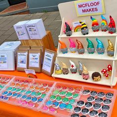 there are many cupcakes on display at the table with other items around it