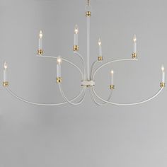 a white chandelier hanging from the ceiling in a room with grey walls and flooring