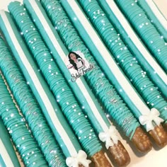 there are many blue and white candy sticks with bows on them, all lined up next to each other