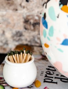 several matches are in a white cup on the table