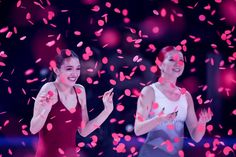 two women standing in front of pink confetti