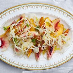 a white plate topped with sliced fruit and veggies