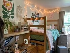 a dorm room with a bed, desk and computer on top of the desk is decorated with string lights