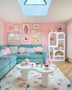 a living room with pink walls and blue couches, white coffee table and art on the wall