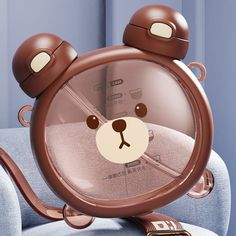 a brown bear clock sitting on top of a blue chair