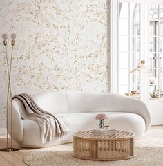 a living room with white furniture and wallpaper