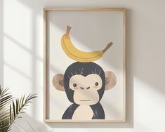 a monkey with a banana on it's head hangs in front of a white wall