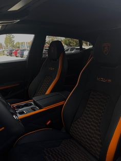 the interior of a sports car with orange stitching