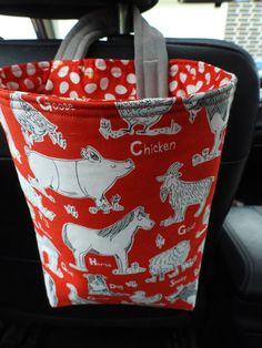 a red and white bag with animals on it in the back seat of a car