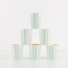 six striped cups stacked on top of each other in front of a white wall and floor