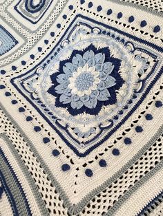 a blue and white crocheted blanket with an intricate design on the bottom corner