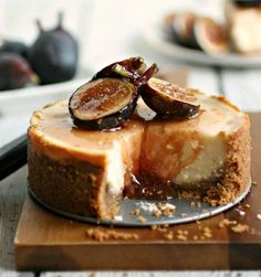 a cheesecake with figs on top is sitting on a cutting board