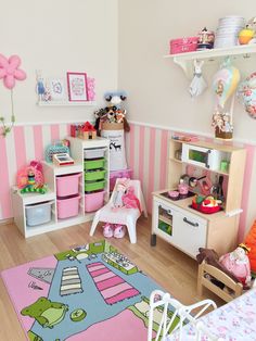 a child's bedroom with pink and white striped walls